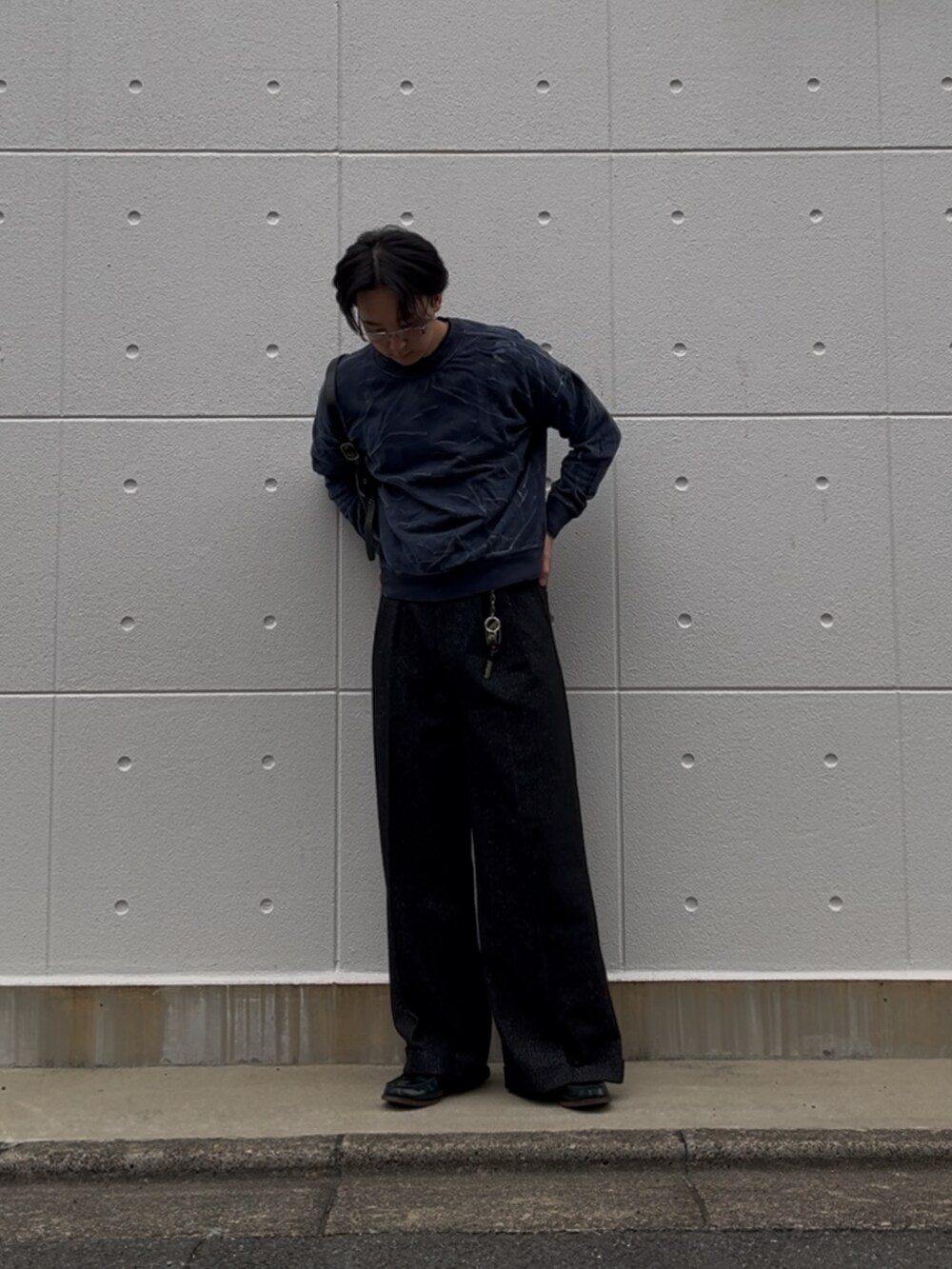 ブラック系のパンツ、ブルー系のスウェット、ブラック系のショルダーバッグを着用したメンズの秋コーディネートの2枚目の写真