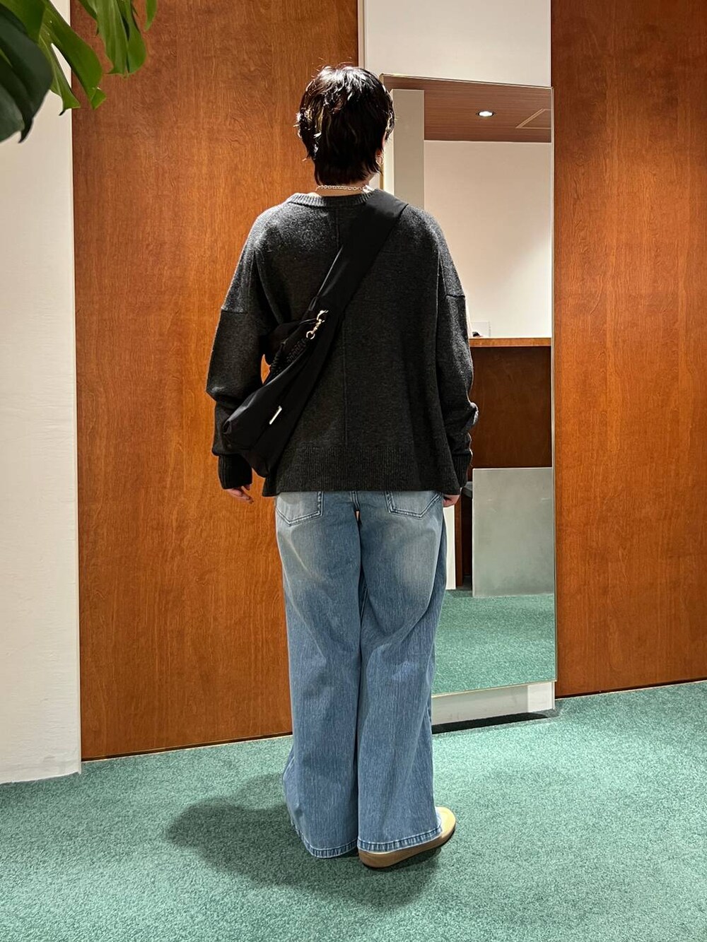 グレー系のピーコート、ブラック系のショルダーバッグ、グレー系のニット/セーターを着用したレディースの冬コーディネートの3枚目の写真