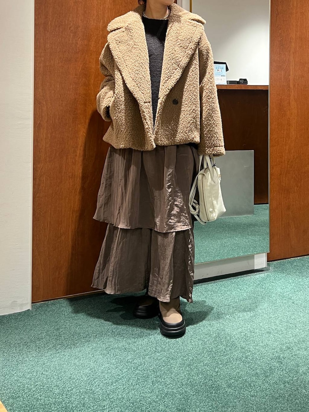 イエロー系のピーコート、ホワイト系のTシャツ/カットソー、グリーン系のブーツを着用したレディースの冬コーディネートの4枚目の写真