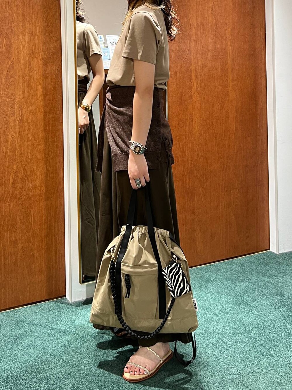 ブラウン系のスカート、ベージュ系のサンダル、ブラウン系のバックパック/リュックを着用したレディースの夏コーディネートの2枚目の写真