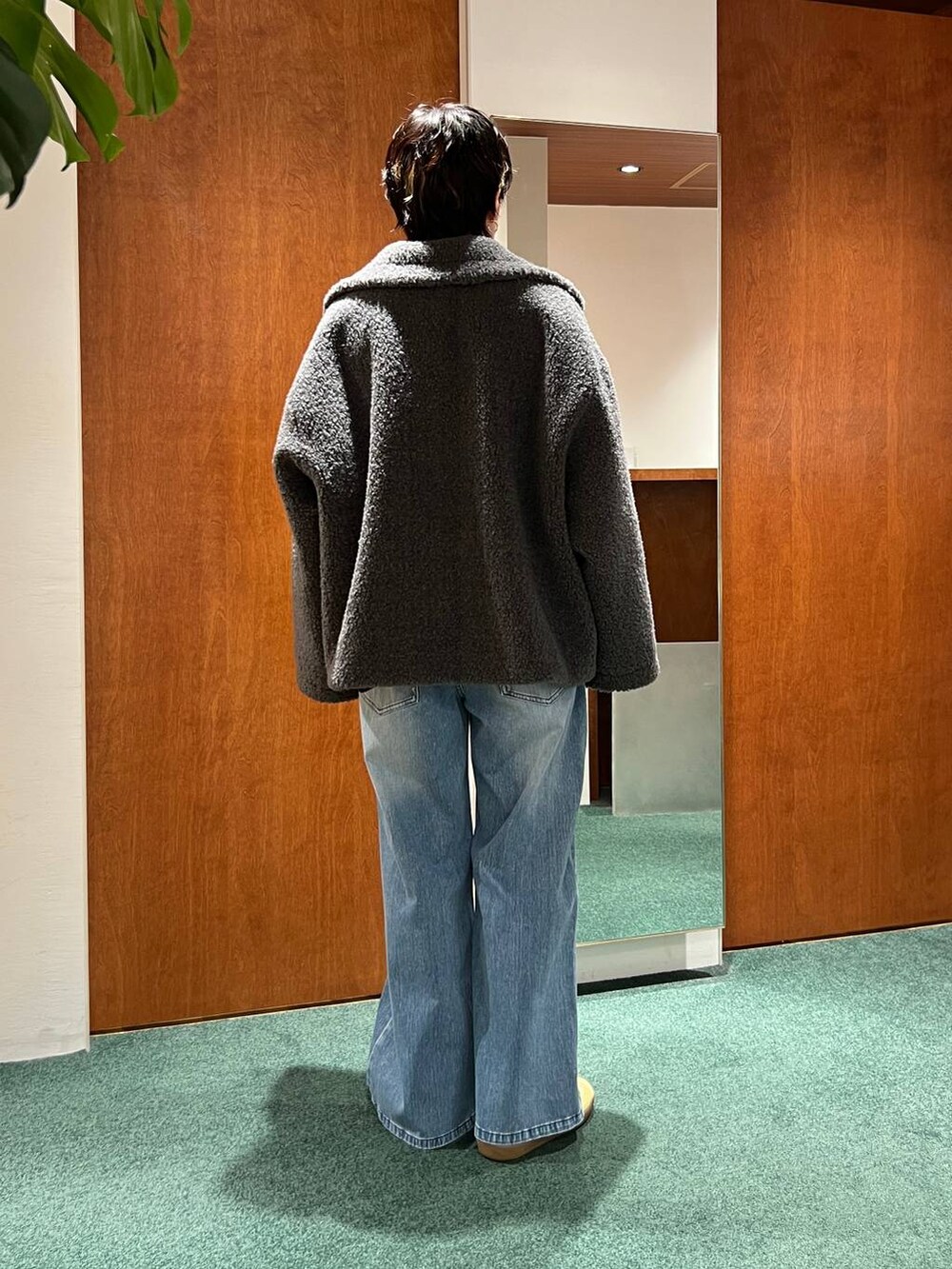 グレー系のピーコート、ブラック系のショルダーバッグ、グレー系のニット/セーターを着用したレディースの冬コーディネートの7枚目の写真