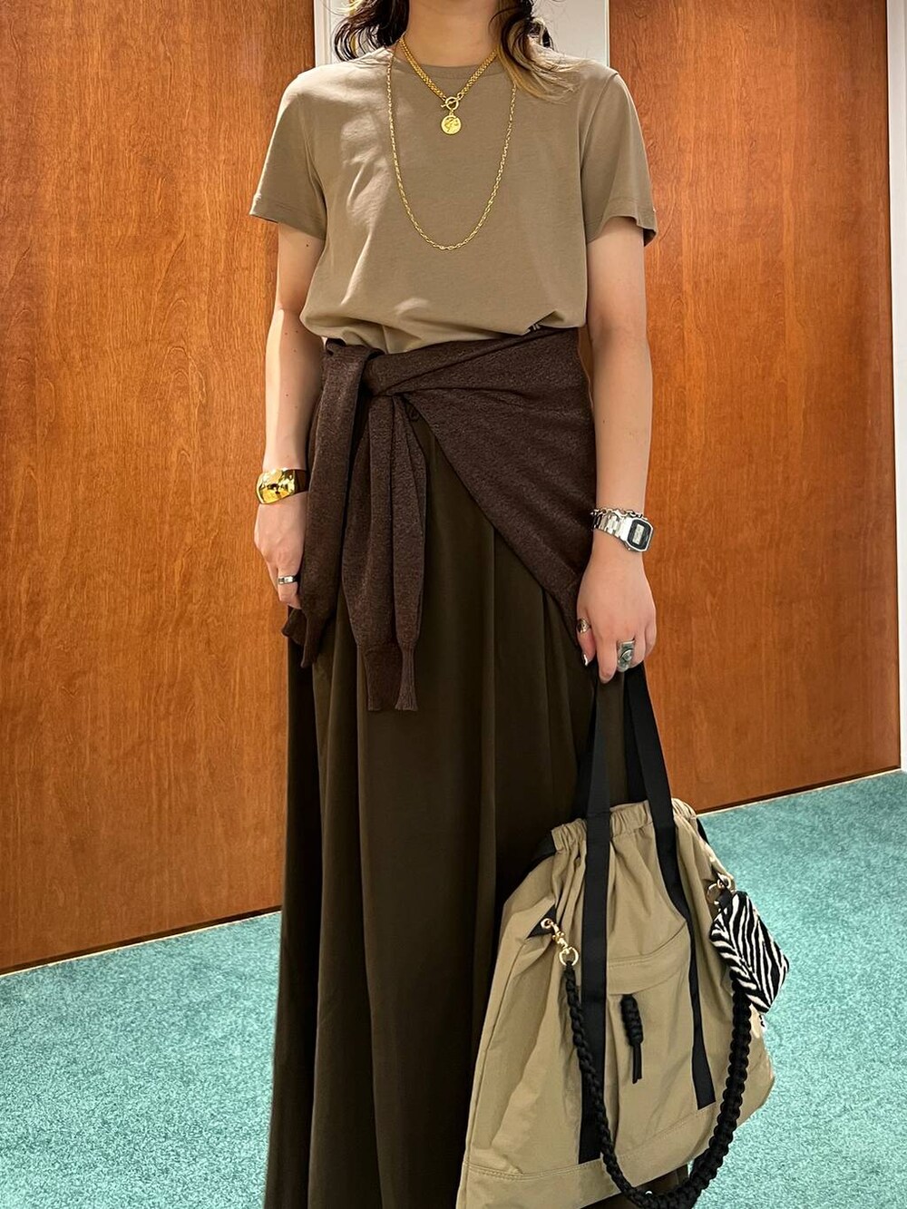 ブラウン系のスカート、ベージュ系のサンダル、ブラウン系のバックパック/リュックを着用したレディースの夏コーディネートの4枚目の写真