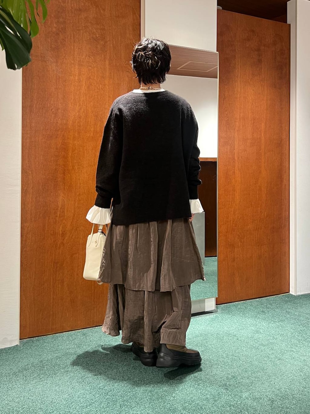 イエロー系のピーコート、ホワイト系のTシャツ/カットソー、グリーン系のブーツを着用したレディースの冬コーディネートの3枚目の写真