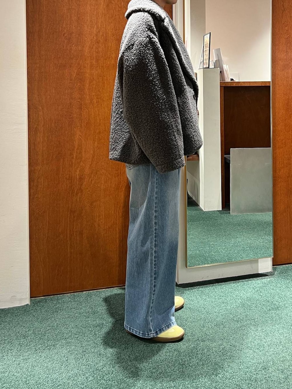 グレー系のピーコート、ブラック系のショルダーバッグ、グレー系のニット/セーターを着用したレディースの冬コーディネートの6枚目の写真