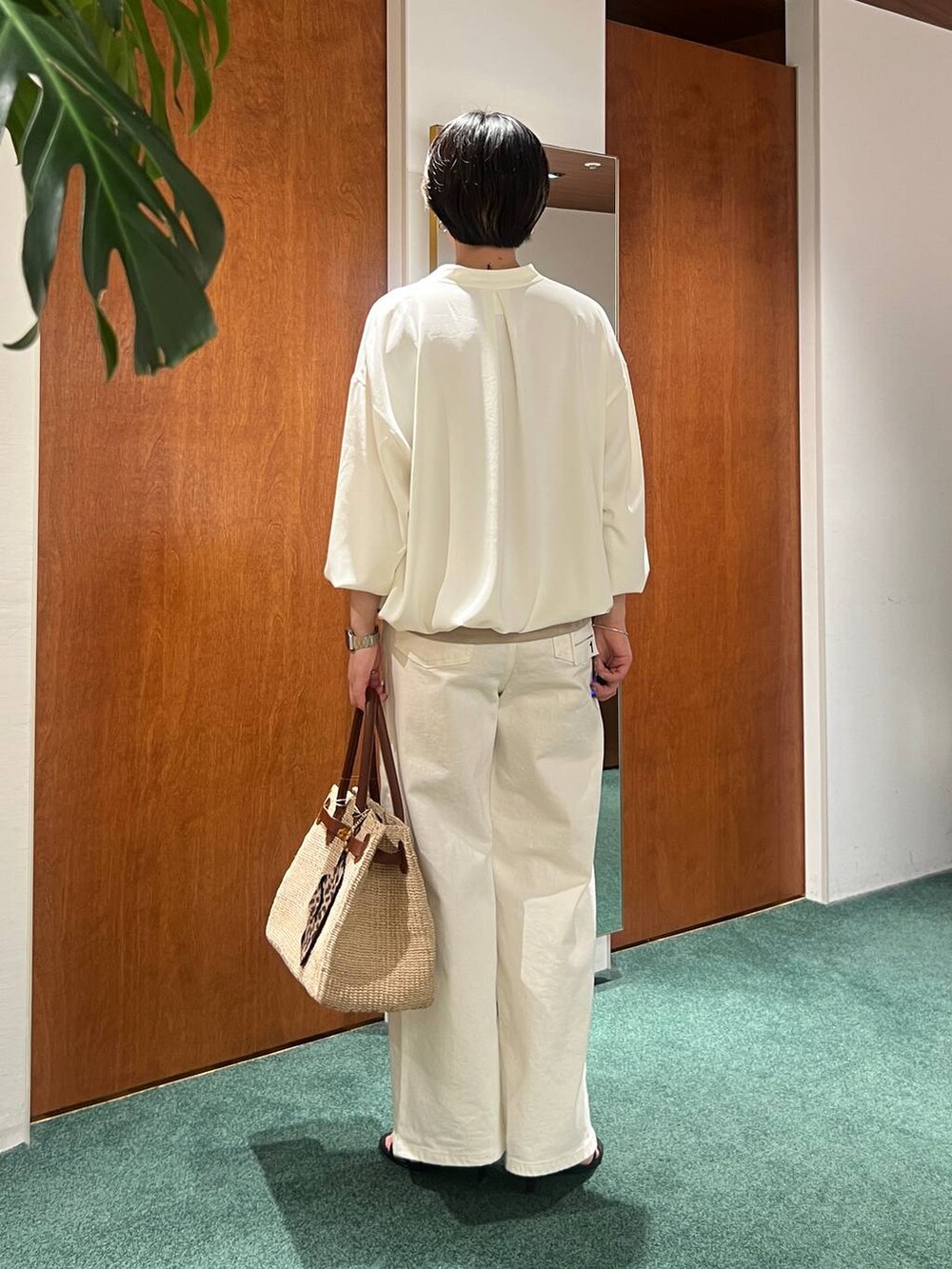 ホワイト系のデニムパンツ、ホワイト系のブルゾン、ベージュ系のキャミソールを着用したレディースの春コーディネートの3枚目の写真