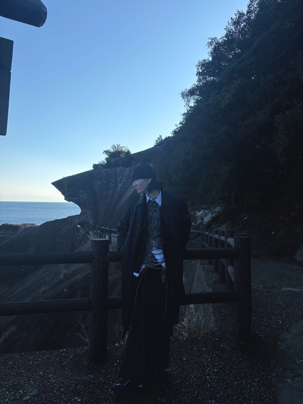 グレー系のトレンチコート、グレー系のTシャツ/カットソー、ホワイト系のシャツ/ブラウスを着用したメンズの冬コーディネートの2枚目の写真