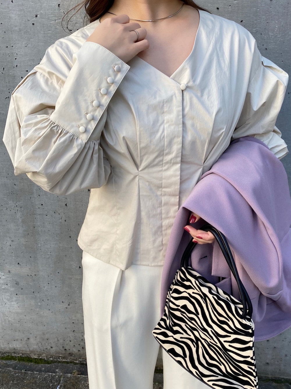 ベージュ系のシャツ/ブラウス、パープル系のテーラードジャケット、グレー系のパンツを着用したレディースの冬コーディネートの5枚目の写真