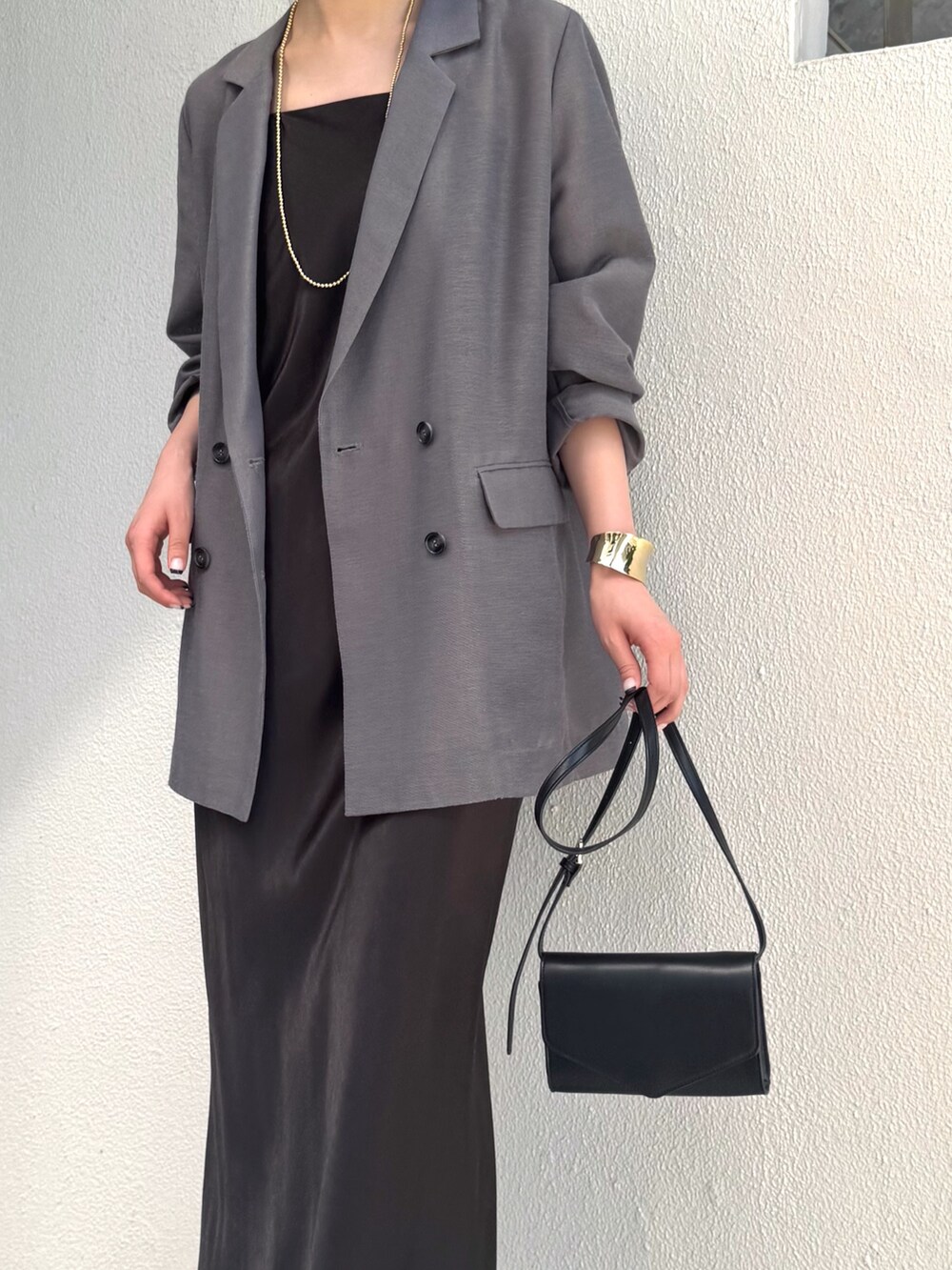 グレー系のワンピース、グレー系のベスト、ブラック系のトートバッグを着用したレディースの夏コーディネートの3枚目の写真