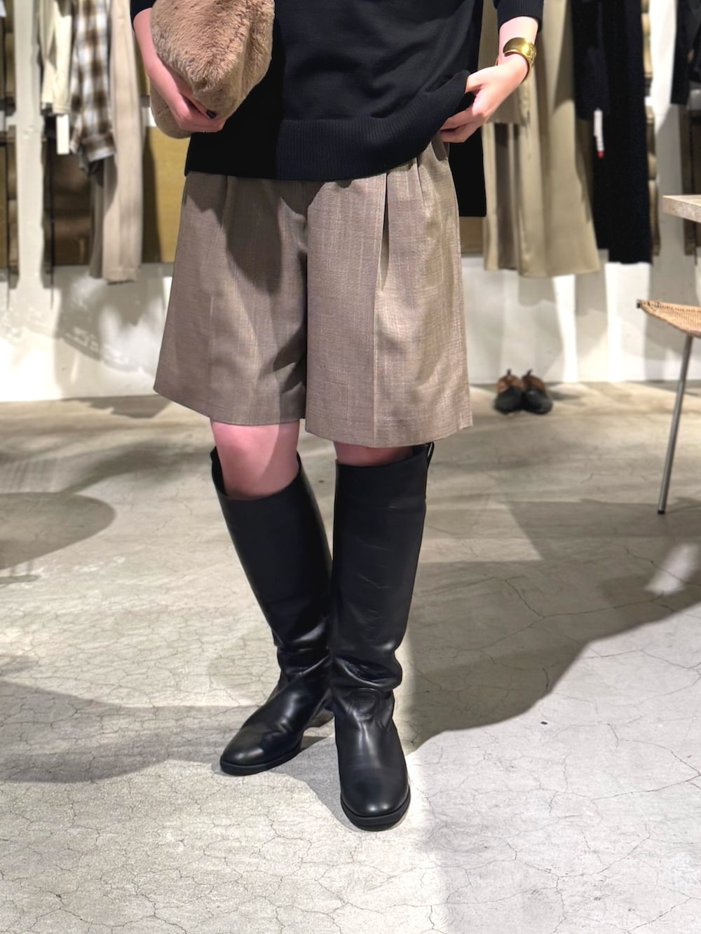 ブラウン系のその他パンツ、ベージュ系のトートバッグ、ブラック系のニット/セーターを着用したレディースの夏コーディネートの2枚目の写真