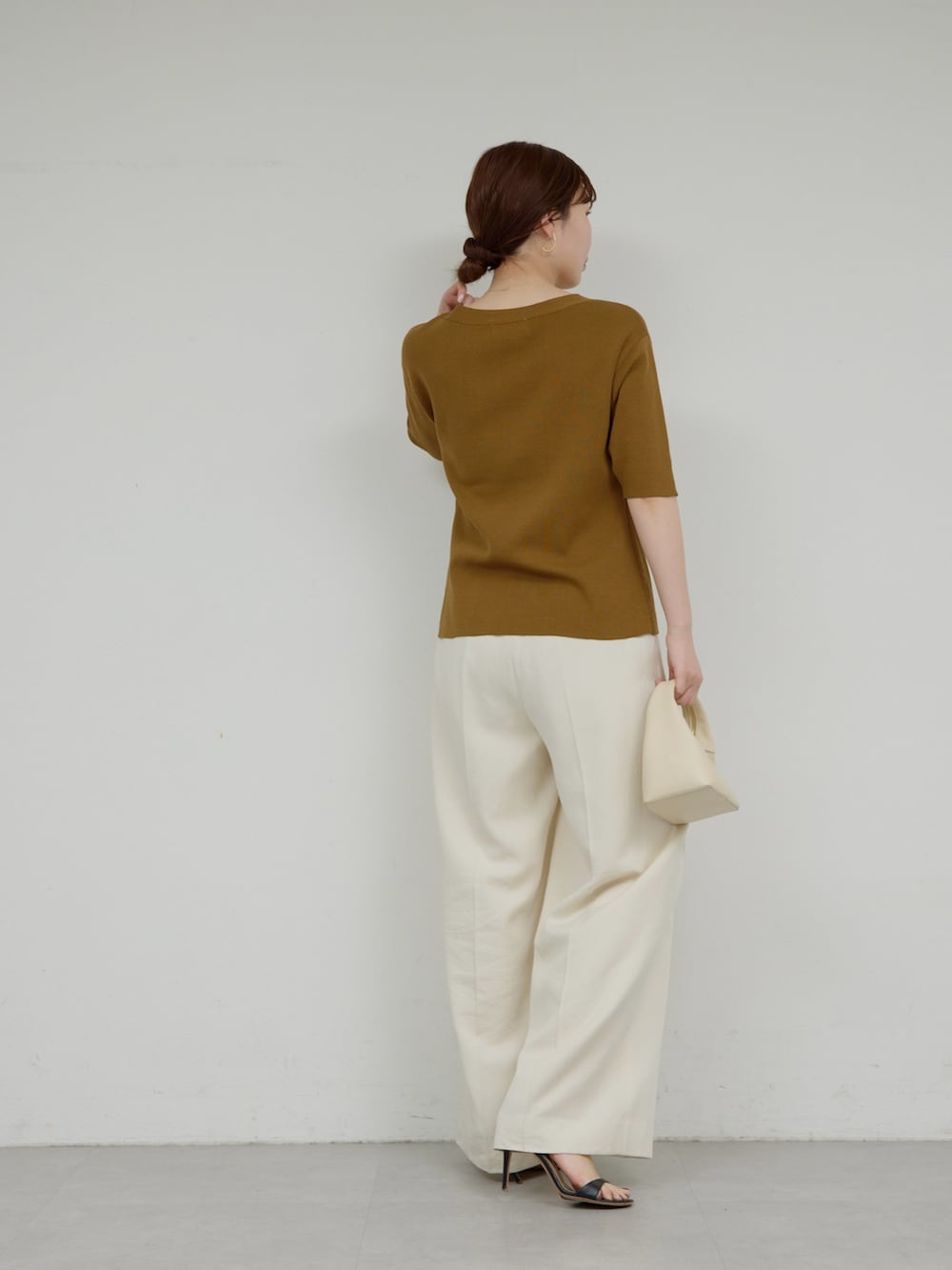 ベージュ系のその他パンツ、ブラウン系のカーディガン/ボレロ、ゴールド系のピアス（両耳用）を着用したレディースの春コーディネートの2枚目の写真