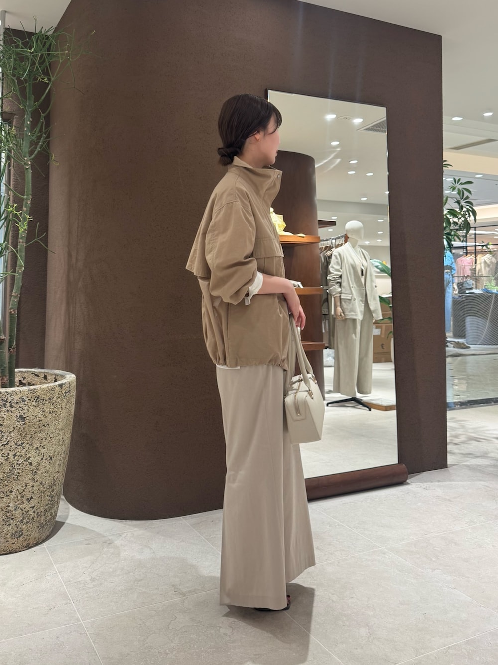 ベージュ系のスカート、ブラウン系のサンダル、ホワイト系のシャツ/ブラウスを着用したレディースの春コーディネートの3枚目の写真