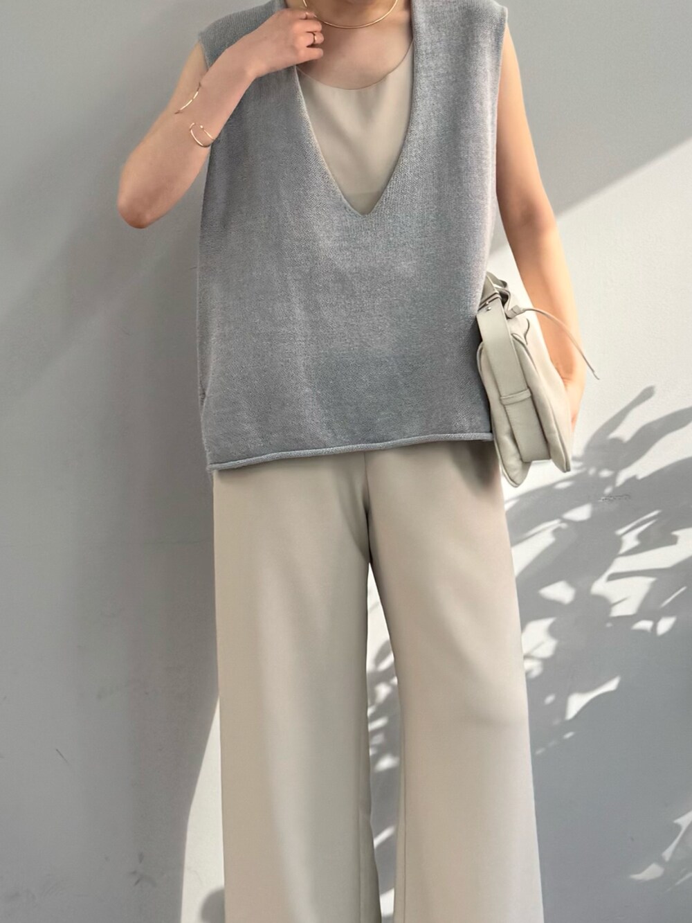 ブラウン系のサンダル、ベージュ系のシャツ/ブラウス、ブルー系のニット/セーターを着用したレディースの春コーディネートの2枚目の写真