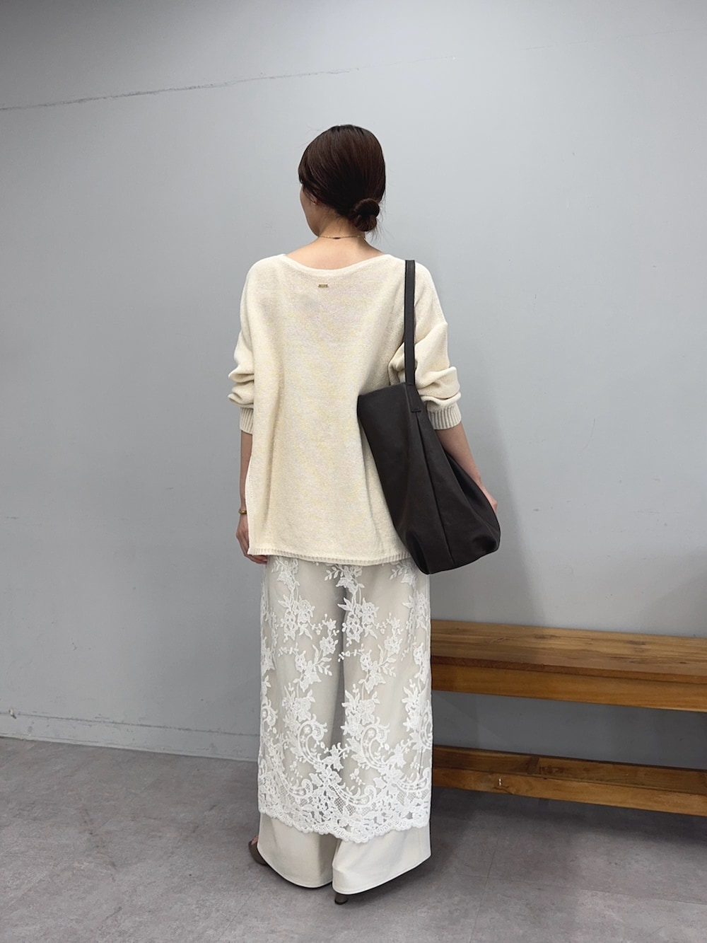 ホワイト系のニット/セーター、ホワイト系のワンピース、ブラウン系のショルダーバッグを着用したレディースの春コーディネートの2枚目の写真