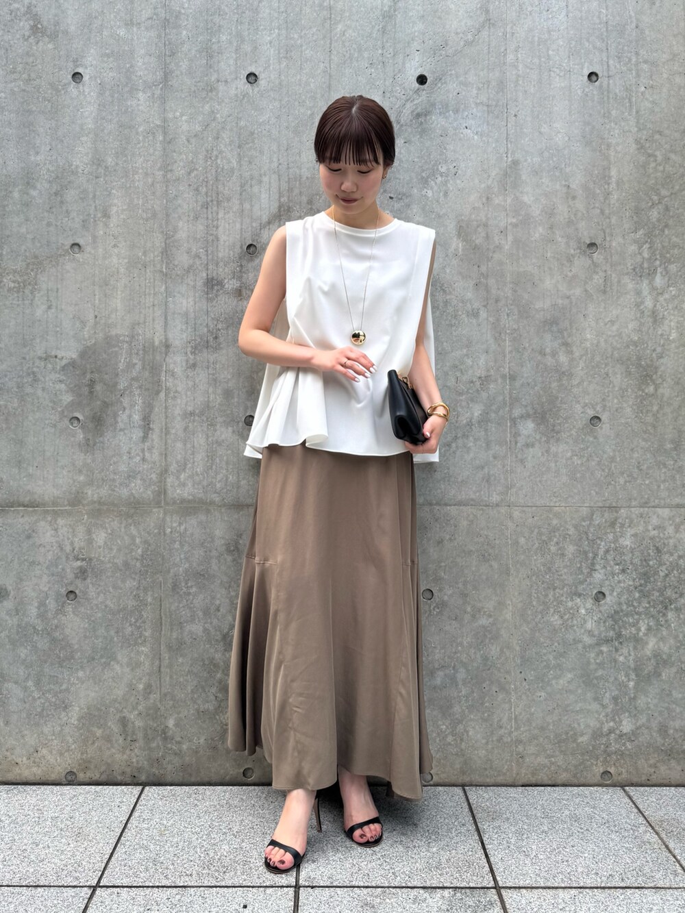 ホワイト系のTシャツ/カットソー、ブラウン系のスカート、ゴールド系のリングを着用したレディースの夏コーディネートの2枚目の写真