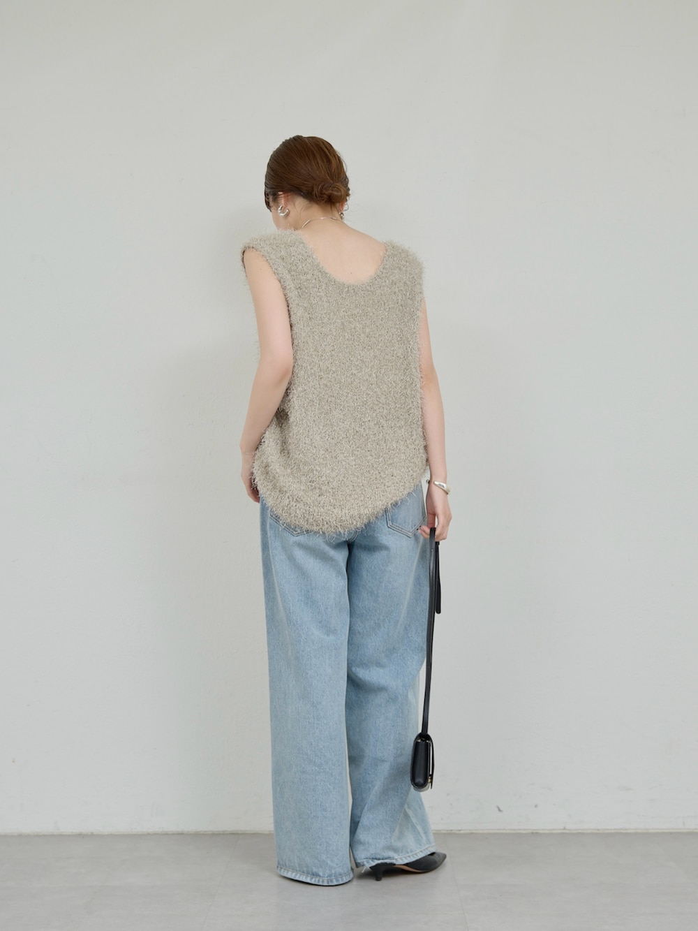 グレー系のニット/セーター、ブルー系のデニムパンツ、ブラック系のトートバッグを着用したレディースの夏コーディネートの3枚目の写真
