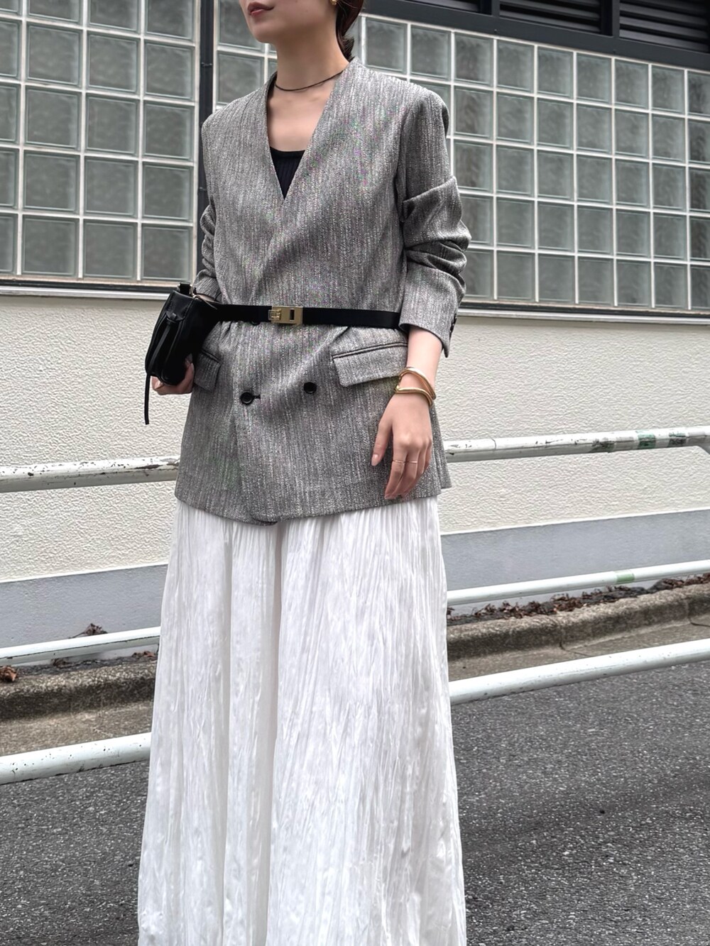 ブラック系のショルダーバッグ、ブラック系のその他アウター、ホワイト系のスカートを着用したレディースの冬コーディネートの4枚目の写真