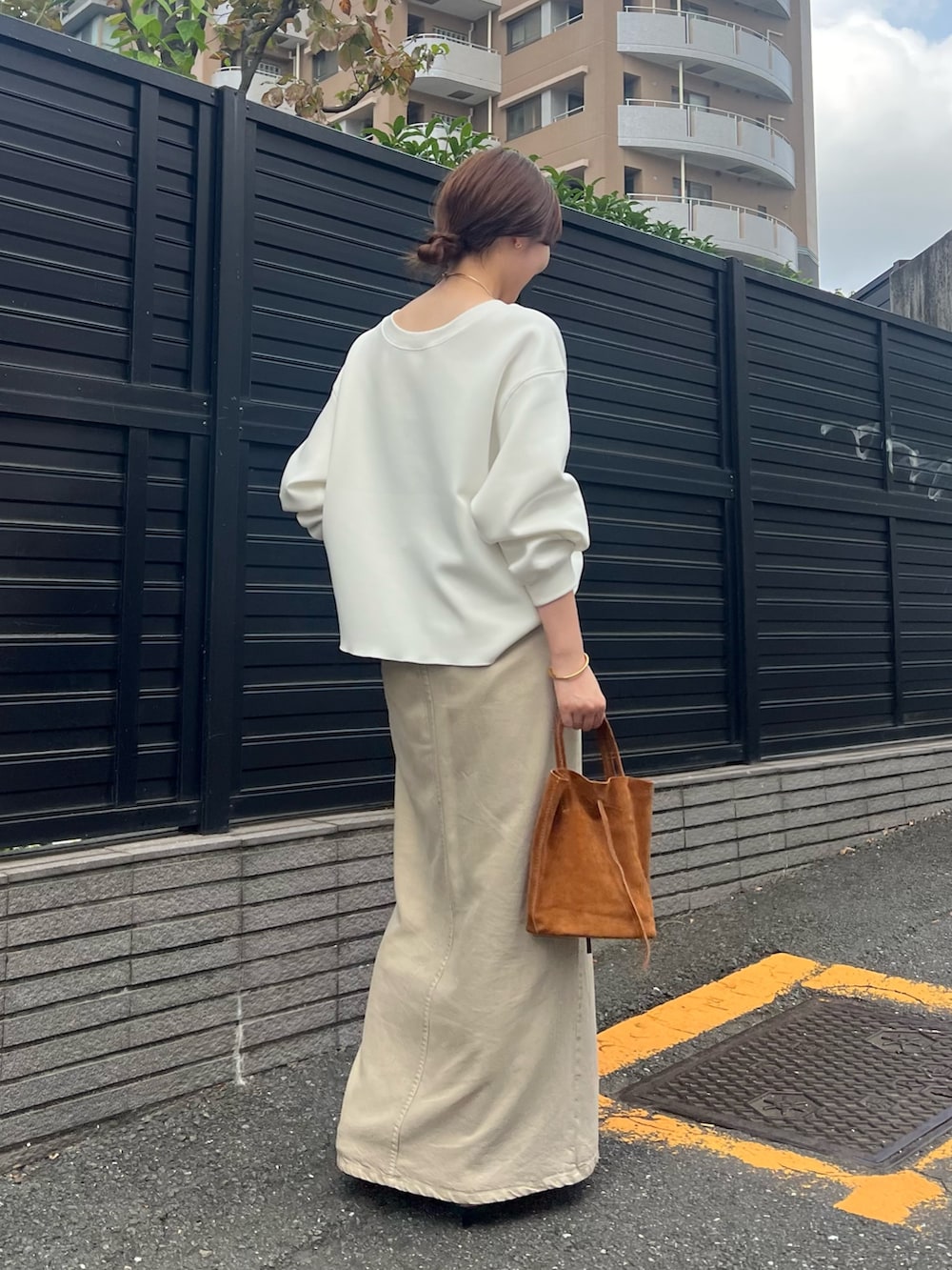 ベージュ系のスカート、ホワイト系のTシャツ/カットソー、ブラック系のベルトを着用したレディースの春コーディネートの3枚目の写真