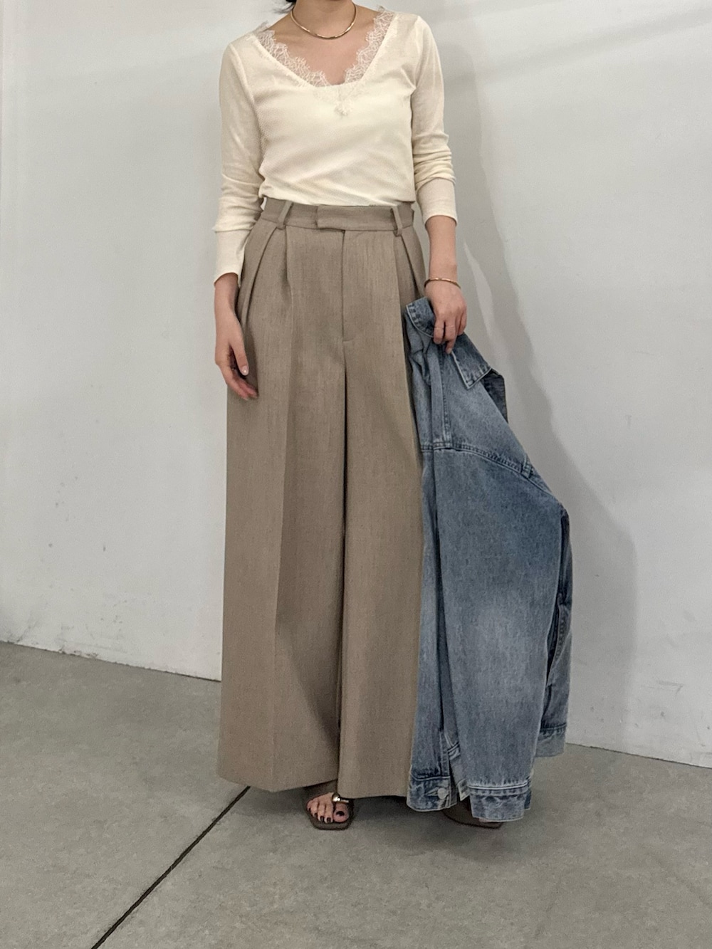 ベージュ系のその他パンツ、ブラウン系のサンダル、ブルー系のベストを着用したレディースの冬コーディネートの2枚目の写真