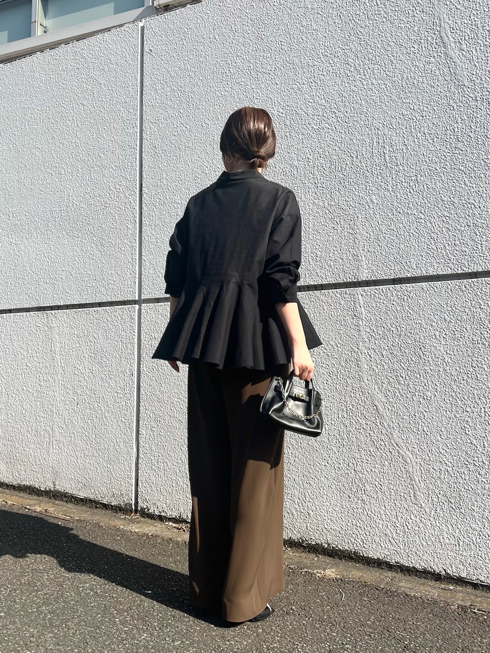 ブラウン系のその他パンツ、ブラック系のサンダル、ブラック系のシャツ/ブラウスを着用したレディースの春コーディネートの2枚目の写真