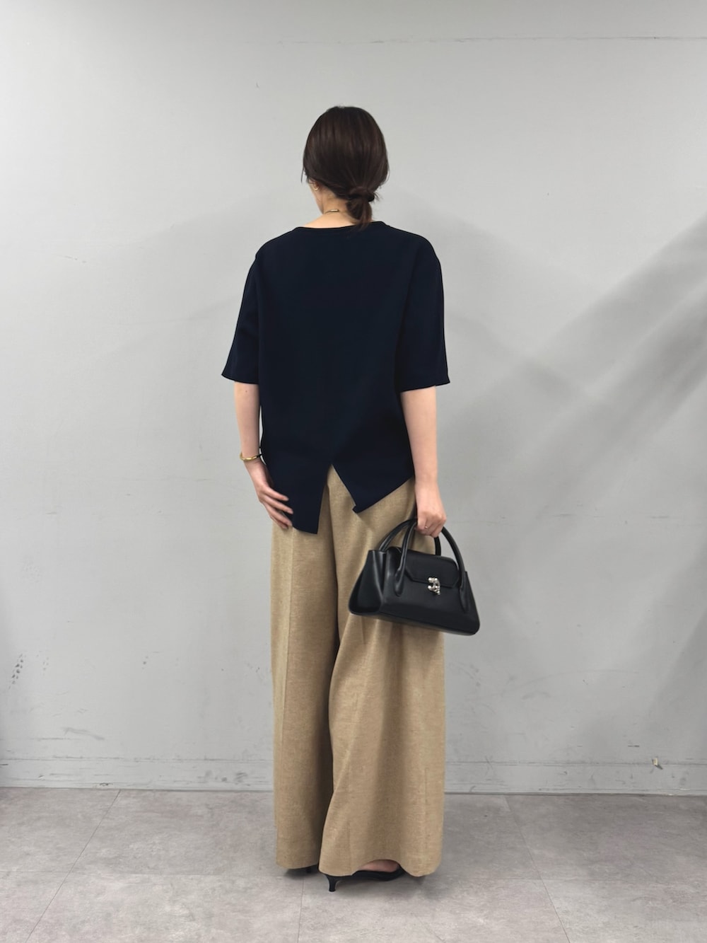 ベージュ系のスラックス、ブルー系のシャツ/ブラウス、ブラック系のサンダルを着用したレディースの夏コーディネートの2枚目の写真
