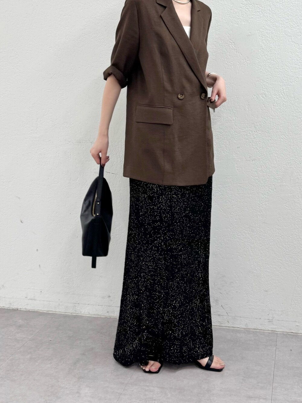 ブラウン系のテーラードジャケット、ブラック系のスカート、ブラック系のトートバッグを着用したレディースの春コーディネートの2枚目の写真