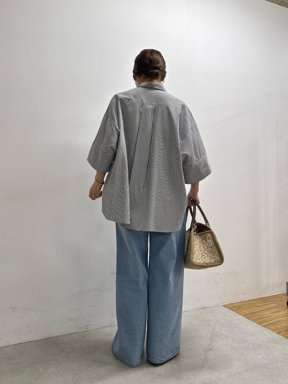 ブルー系のシャツ/ブラウス、ブルー系のデニムパンツ、ベージュ系のトートバッグを着用したレディースの春コーディネートの5枚目の写真