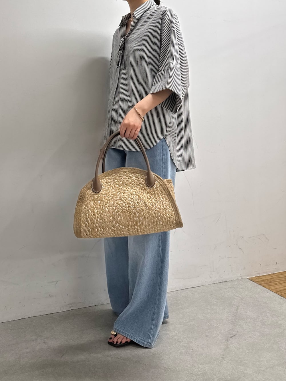 ブルー系のシャツ/ブラウス、ブルー系のデニムパンツ、ベージュ系のトートバッグを着用したレディースの春コーディネートの3枚目の写真