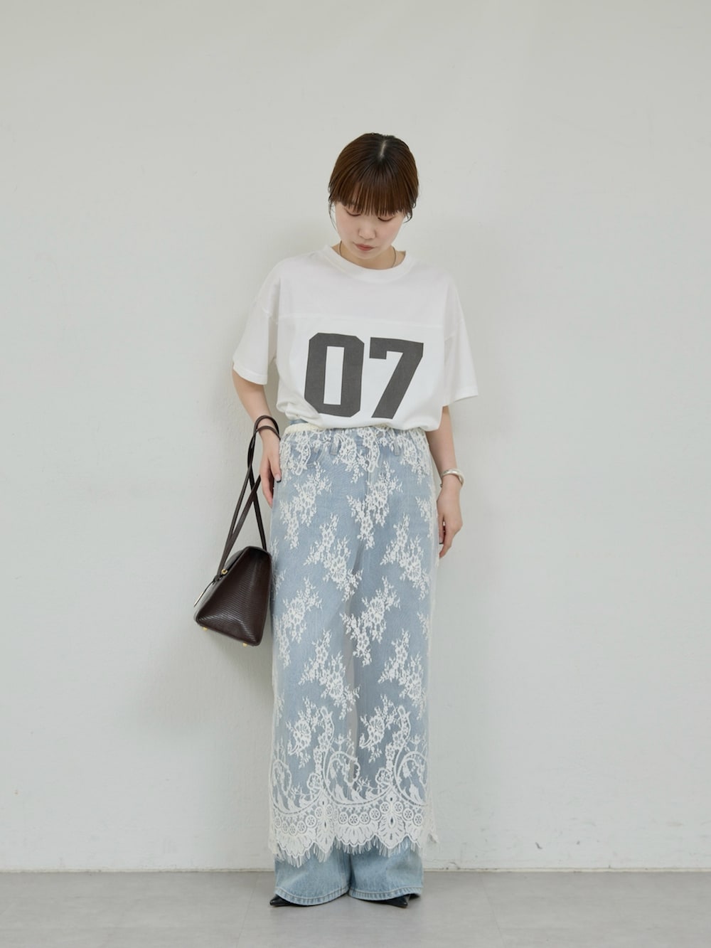 ホワイト系のスカート、ブルー系のデニムパンツ、ホワイト系のTシャツ/カットソーを着用したレディースの夏コーディネートの2枚目の写真