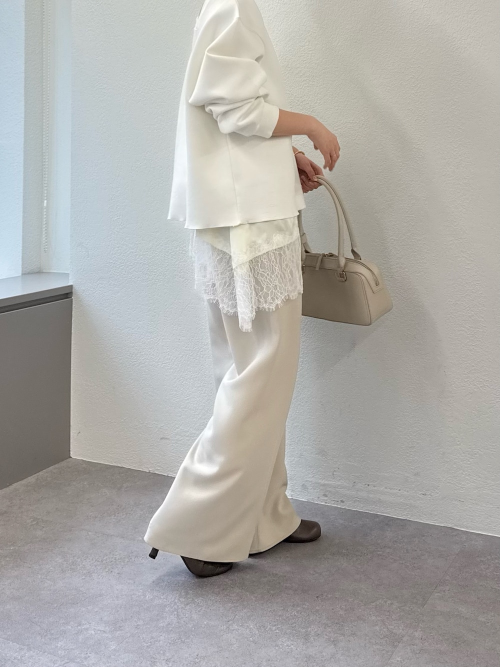 ベージュ系のその他パンツ、ホワイト系のボストンバッグ、ホワイト系のTシャツ/カットソーを着用したレディースの春コーディネートの2枚目の写真