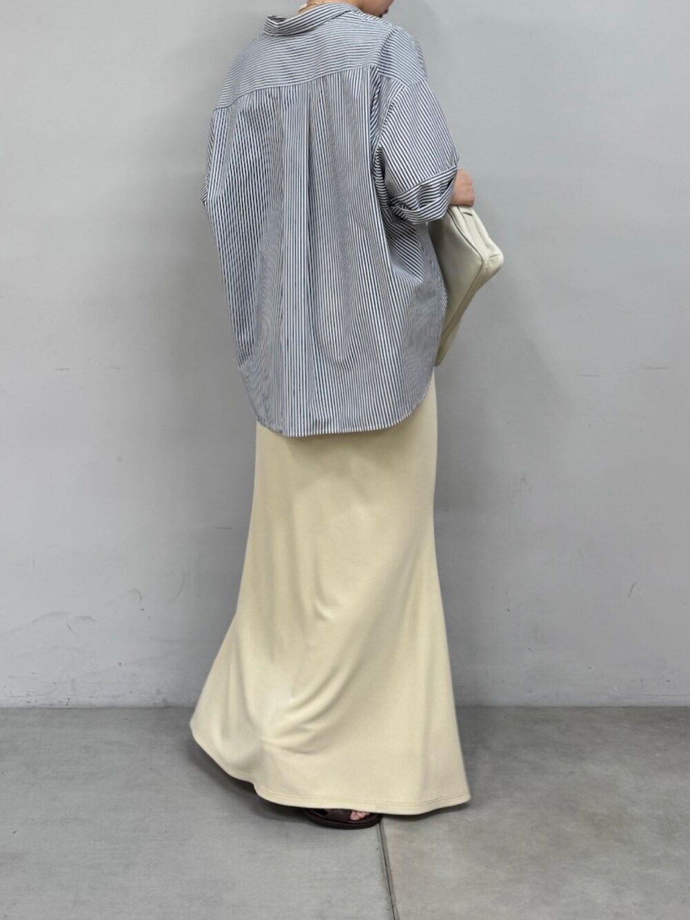 ブルー系のシャツ/ブラウス、ホワイト系のショルダーバッグ、ブラウン系のサンダルを着用したレディースの春コーディネートの2枚目の写真