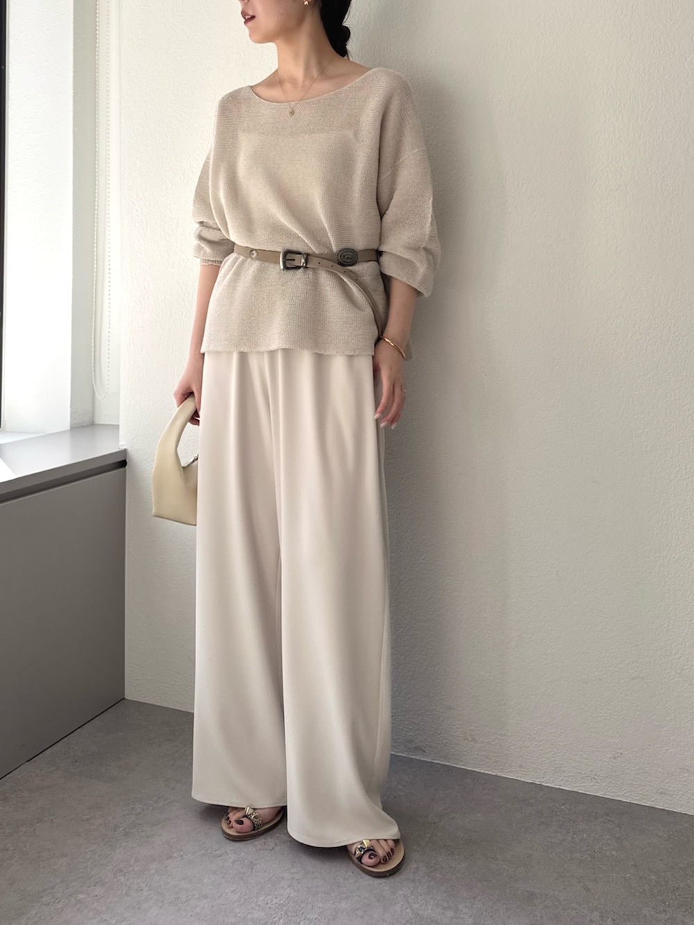 ベージュ系のその他パンツ、ベージュ系のニット/セーター、グレー系のベルトを着用したレディースの春コーディネートの2枚目の写真
