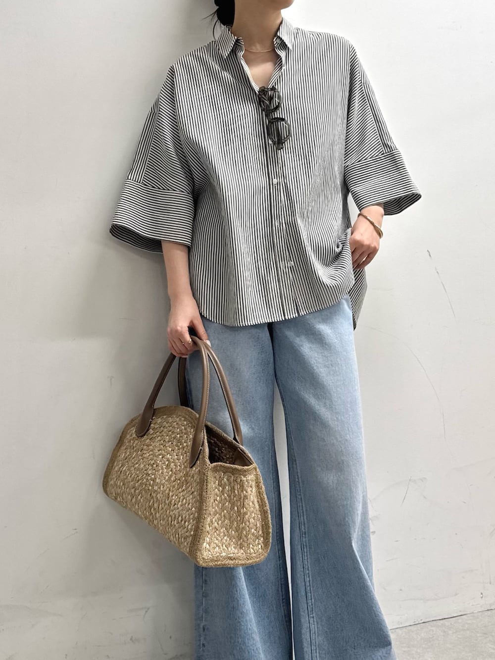 ブルー系のシャツ/ブラウス、ブルー系のデニムパンツ、ベージュ系のトートバッグを着用したレディースの春コーディネートの4枚目の写真