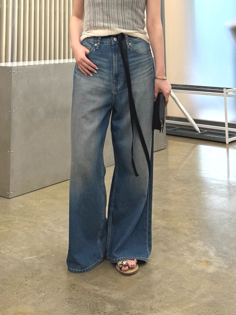 ブルー系のデニムパンツ、ゴールド系のネックレスを着用したレディースの春コーディネートの2枚目の写真