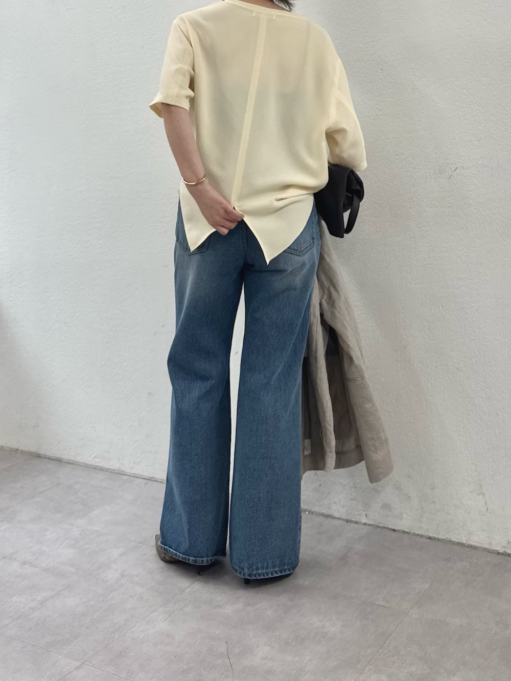 イエロー系のシャツ/ブラウス、ブルー系のデニムパンツ、ホワイト系のその他アウターを着用したレディースの春コーディネートの2枚目の写真