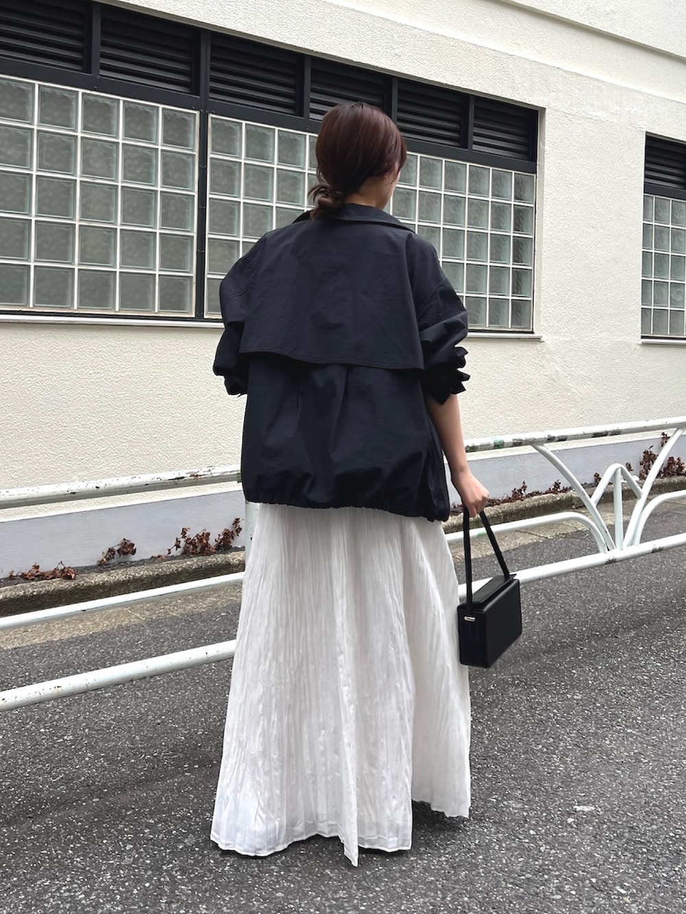 ホワイト系のスカート、ブルー系のブルゾン、ブラック系のニット/セーターを着用したレディースの冬コーディネートの3枚目の写真