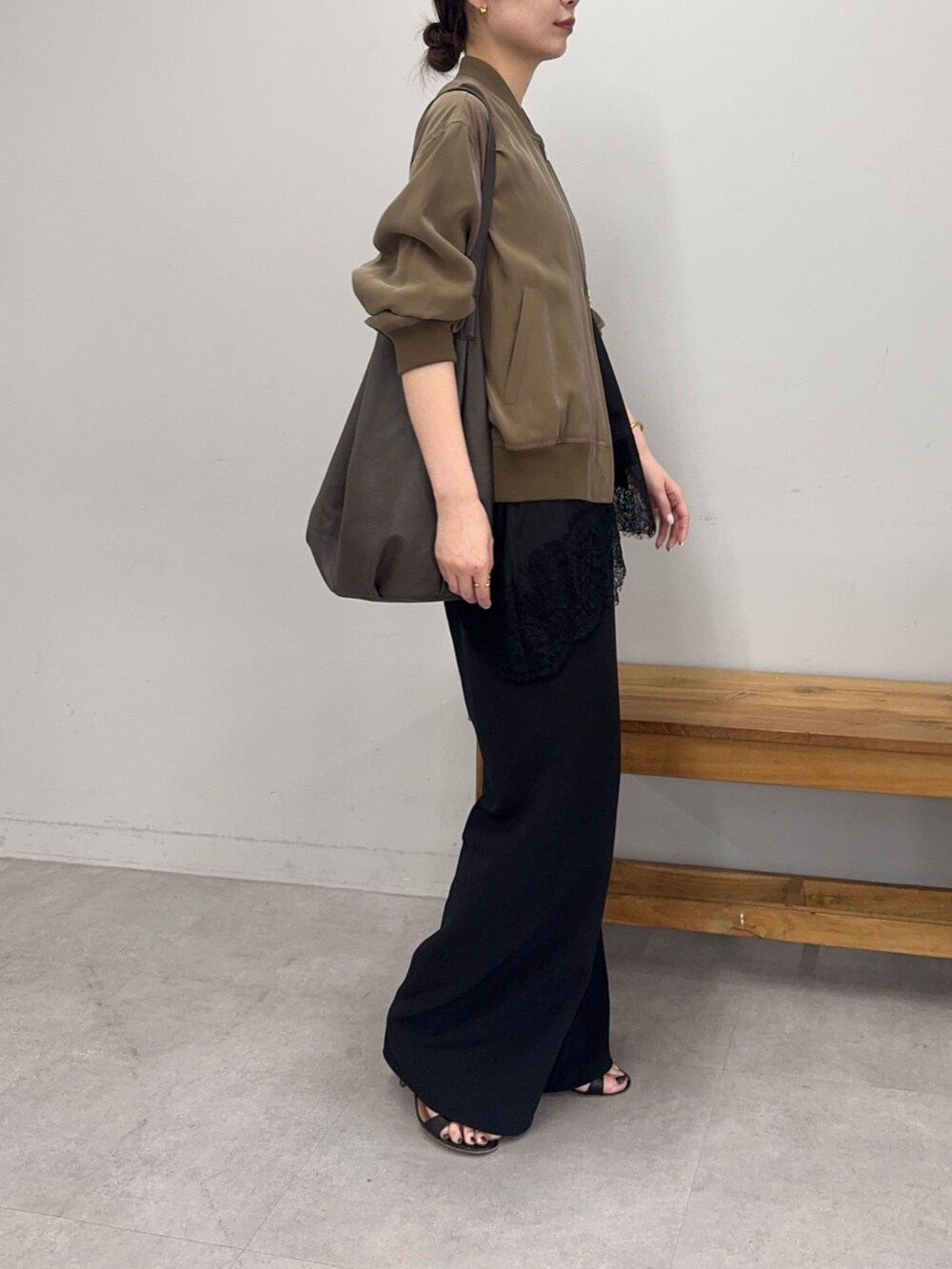 ブラック系のその他パンツ、ブラウン系のショルダーバッグ、グリーン系のブルゾンを着用したレディースの春コーディネートの2枚目の写真