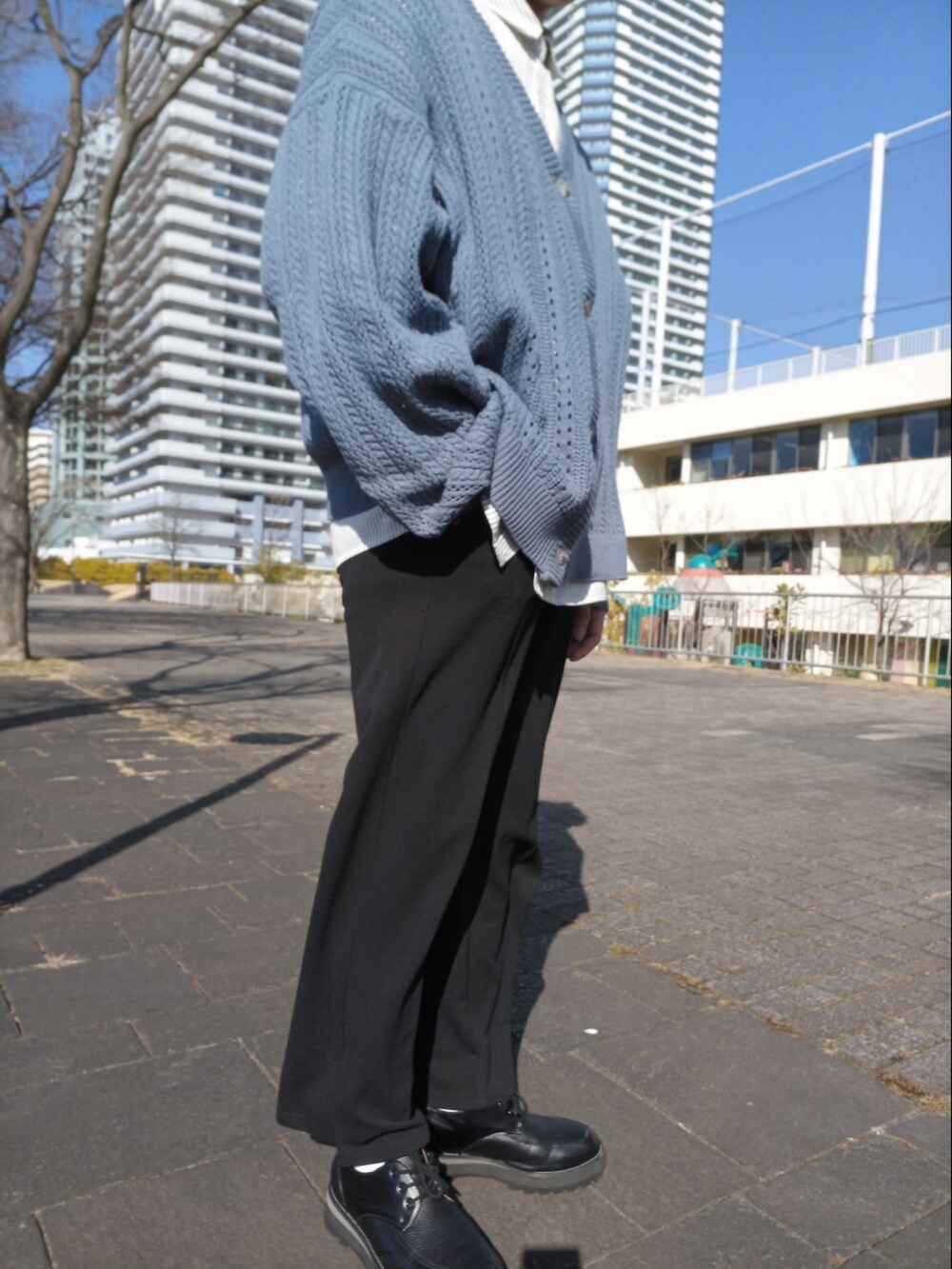 グレー系のシャツ/ブラウス、ブラック系のステンカラーコート、ブルー系のカーディガン/ボレロを着用したメンズの冬コーディネートの2枚目の写真
