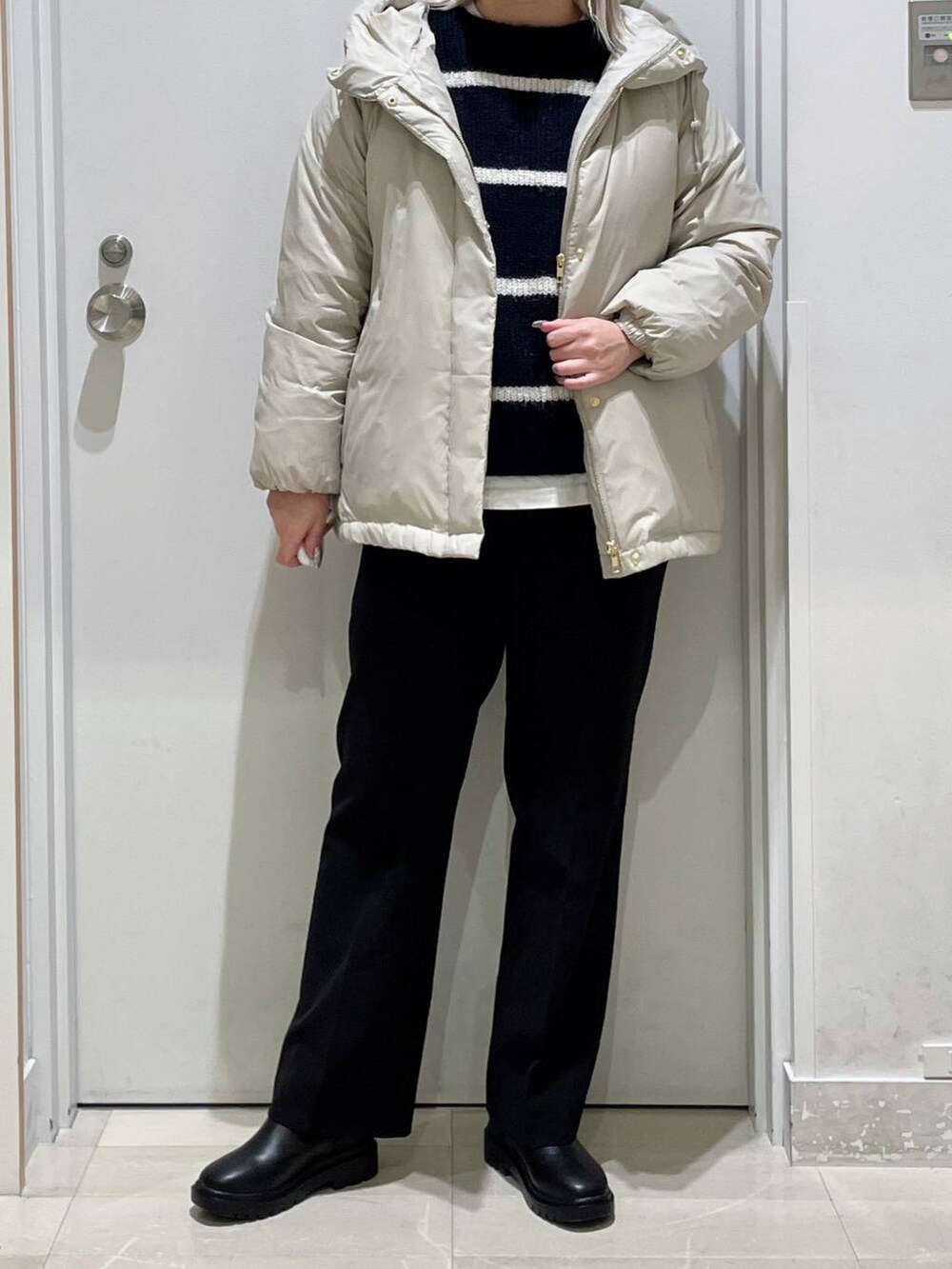 ベージュ系のダウンジャケット/コート、ブラック系のその他パンツ、ホワイト系のTシャツ/カットソーを着用したレディースの冬コーディネートの2枚目の写真