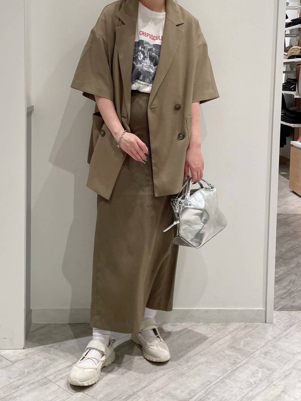 シルバー系のショルダーバッグ、ホワイト系のTシャツ/カットソー、ホワイト系のスニーカーを着用したレディースの春コーディネートの2枚目の写真