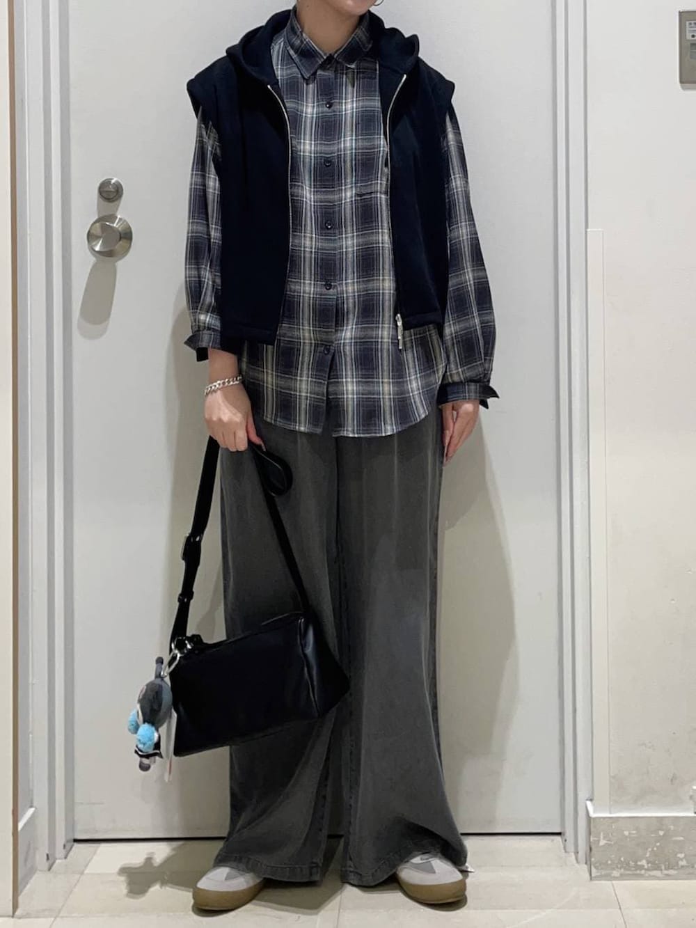 グレー系のスニーカー、ブラック系のシャツ/ブラウス、ブラック系のショルダーバッグを着用したレディースの春コーディネートの2枚目の写真