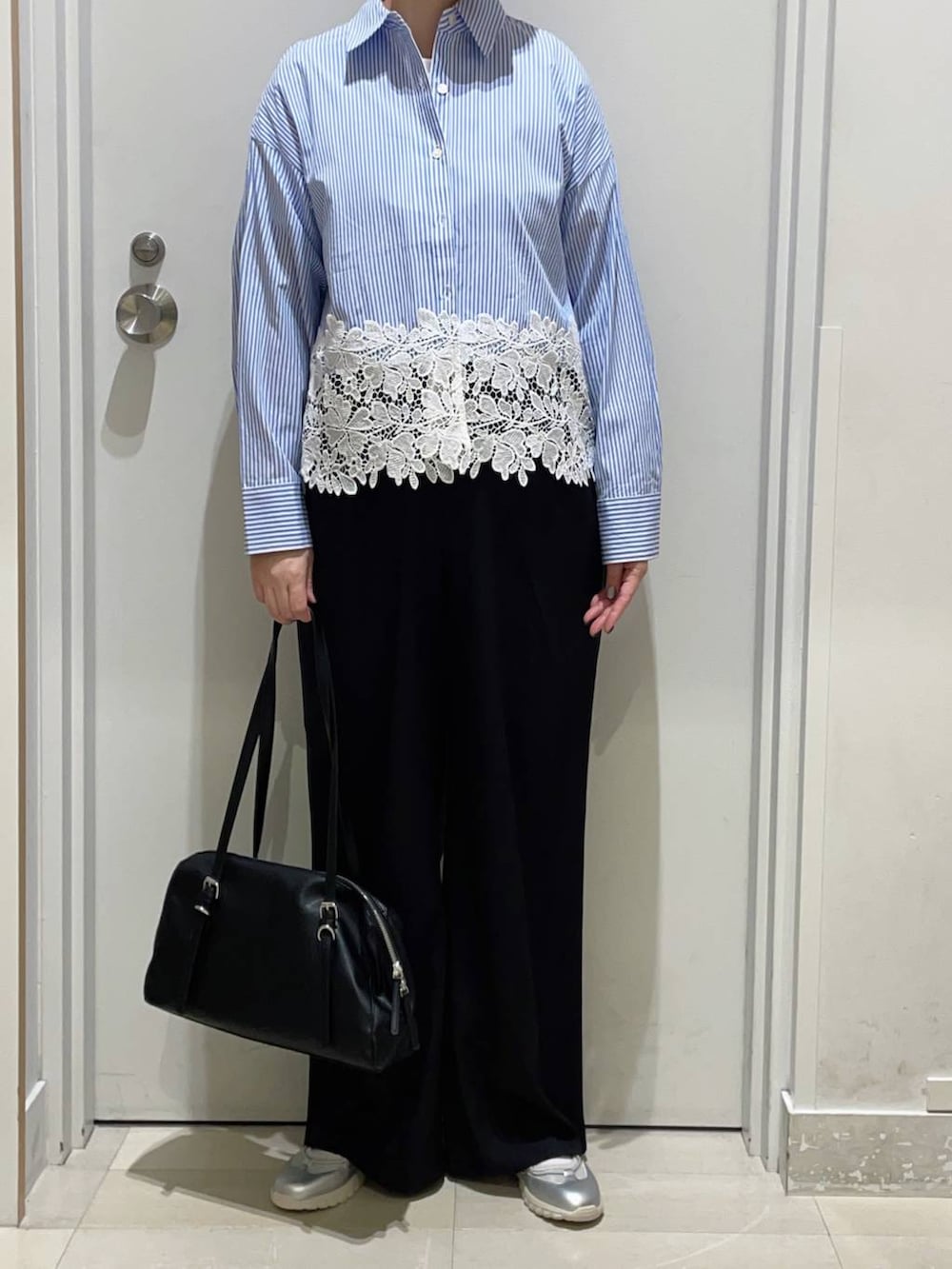 ブラック系のその他パンツ、ブルー系のシャツ/ブラウス、ブラック系のショルダーバッグを着用したレディースの春コーディネートの2枚目の写真