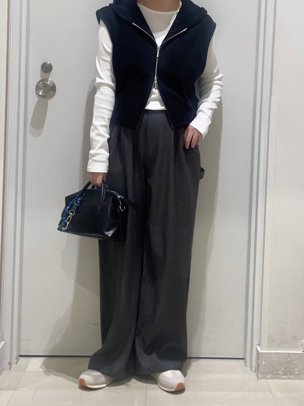 グレー系のその他パンツ、ブラック系のベスト、ブラック系のボストンバッグを着用したレディースの春コーディネートの2枚目の写真