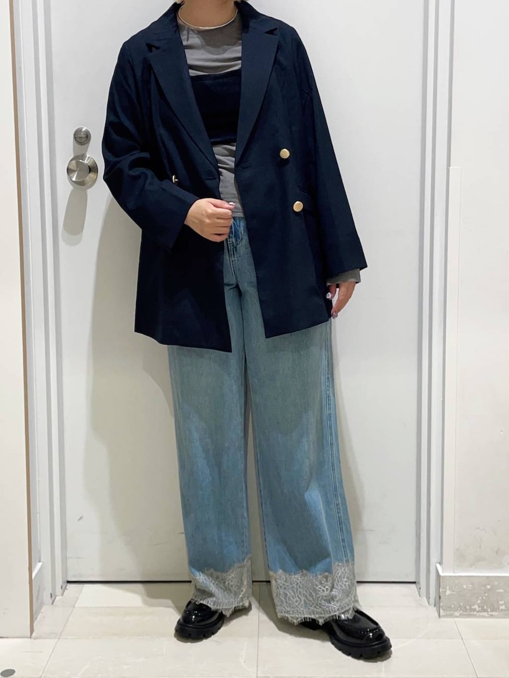 グレー系のTシャツ/カットソー、ブルー系のデニムパンツ、ブルー系のテーラードジャケットを着用したレディースの秋コーディネートの2枚目の写真