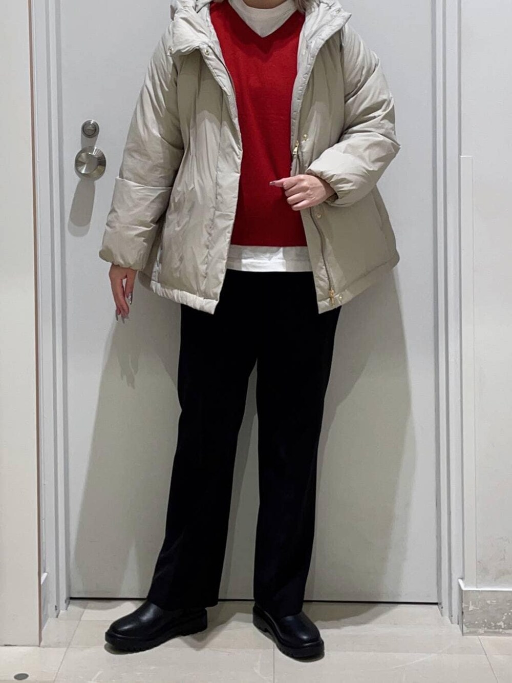 ベージュ系のダウンジャケット/コート、ブラック系のその他パンツ、ホワイト系のTシャツ/カットソーを着用したレディースの冬コーディネートの2枚目の写真