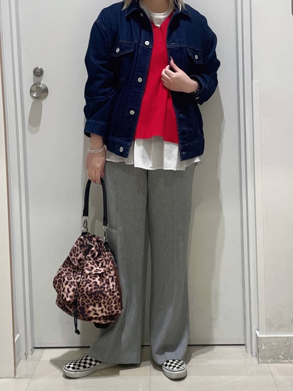 レッド系のニット/セーター、ホワイト系のTシャツ/カットソー、ブルー系のデニムジャケットを着用したレディースの冬コーディネートの2枚目の写真