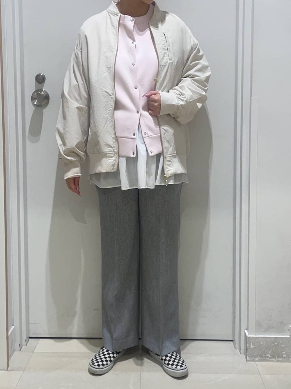 グレー系のその他パンツ、ピンク系のカーディガン/ボレロ、ベージュ系のブルゾンを着用したレディースの春コーディネートの2枚目の写真