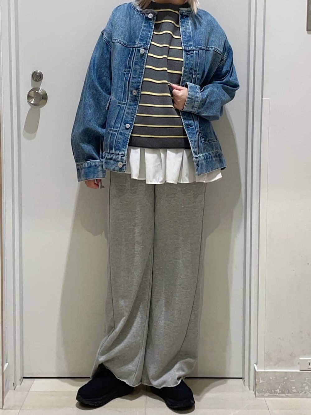 ホワイト系のTシャツ/カットソー、ブルー系のデニムジャケット、グレー系のニット/セーターを着用したレディースの冬コーディネートの2枚目の写真