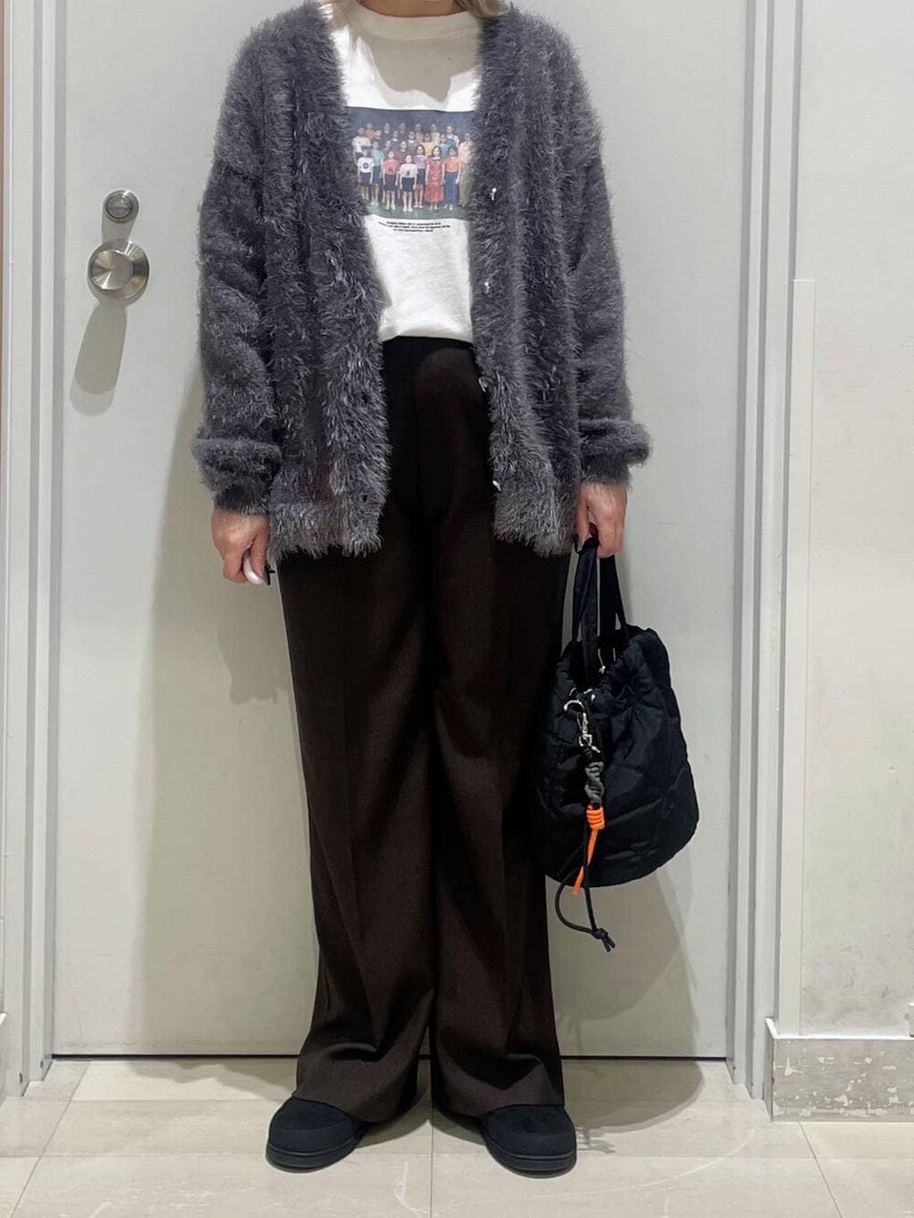 ブラック系のハンドバッグ、ブラウン系のその他パンツ、グレー系のカーディガン/ボレロを着用したレディースの秋コーディネートの2枚目の写真