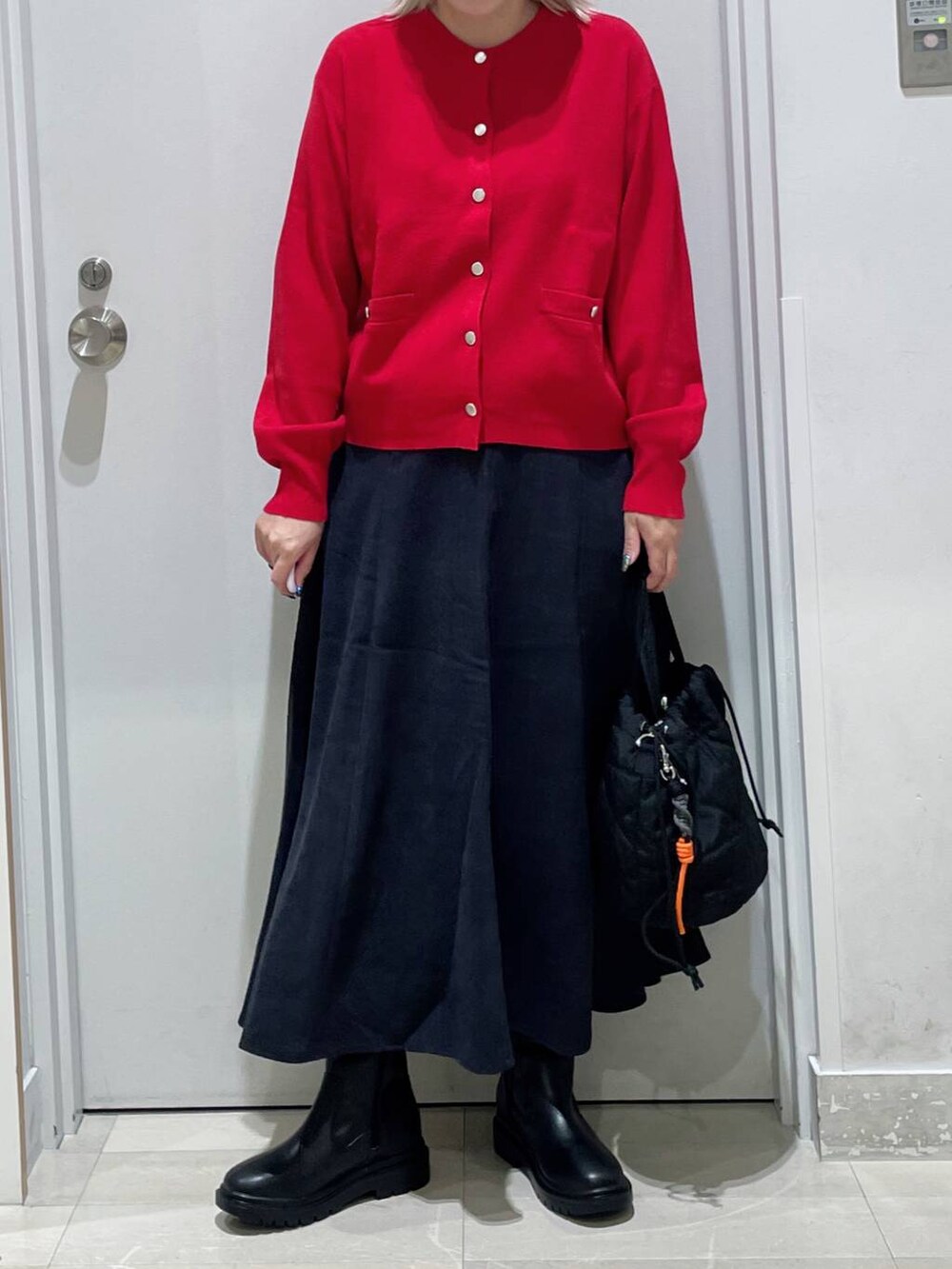 グレー系のスカート、ブラック系のハンドバッグ、レッド系のカーディガン/ボレロを着用したレディースの秋コーディネートの2枚目の写真