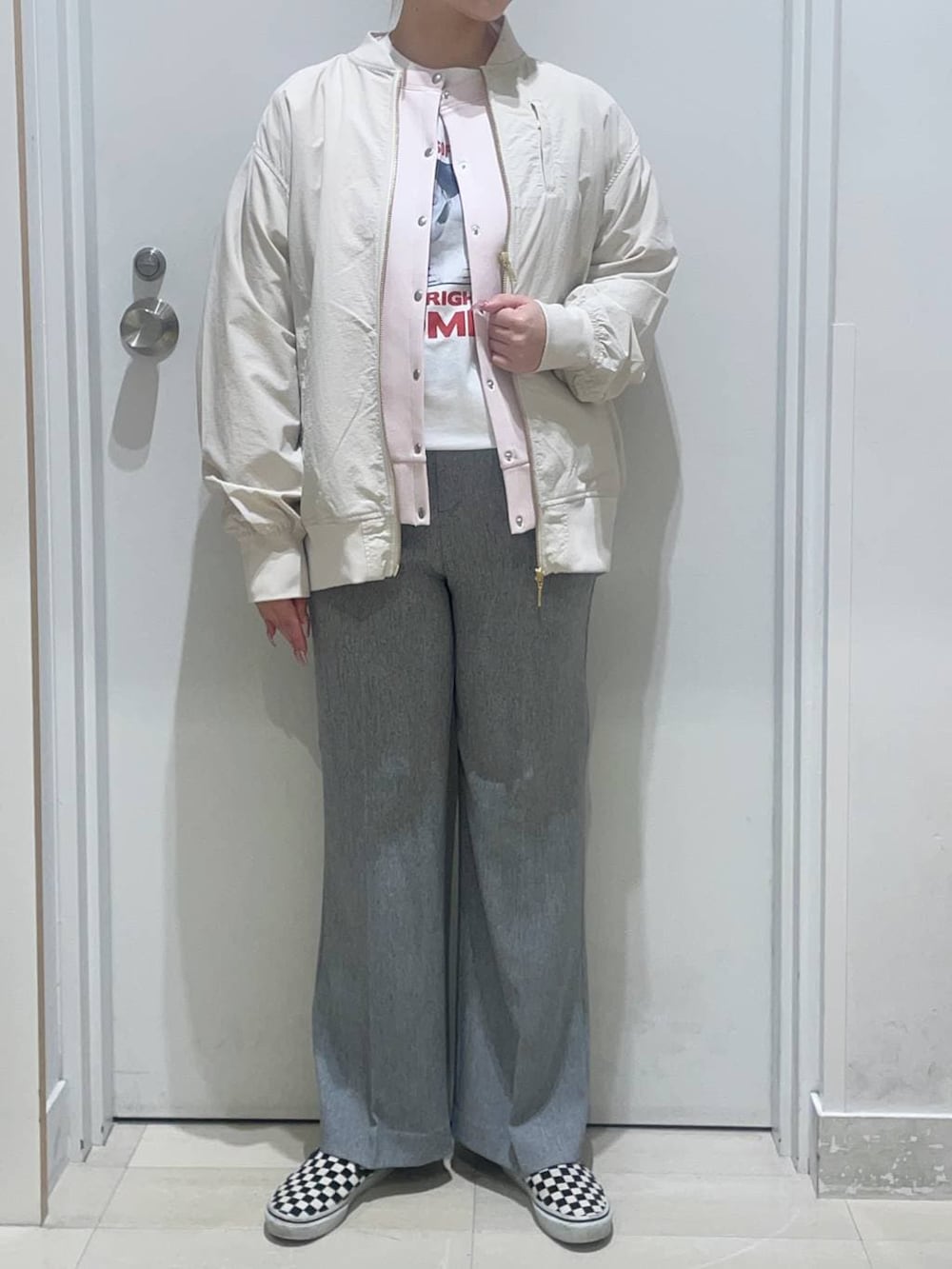 グレー系のその他パンツ、ピンク系のカーディガン/ボレロ、ベージュ系のブルゾンを着用したレディースの春コーディネートの2枚目の写真